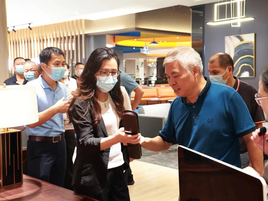 麻豆精品乱码一二三区别蜜臀在线家具集团董事副总裁黄云林为调研组展示实木办公家具产品